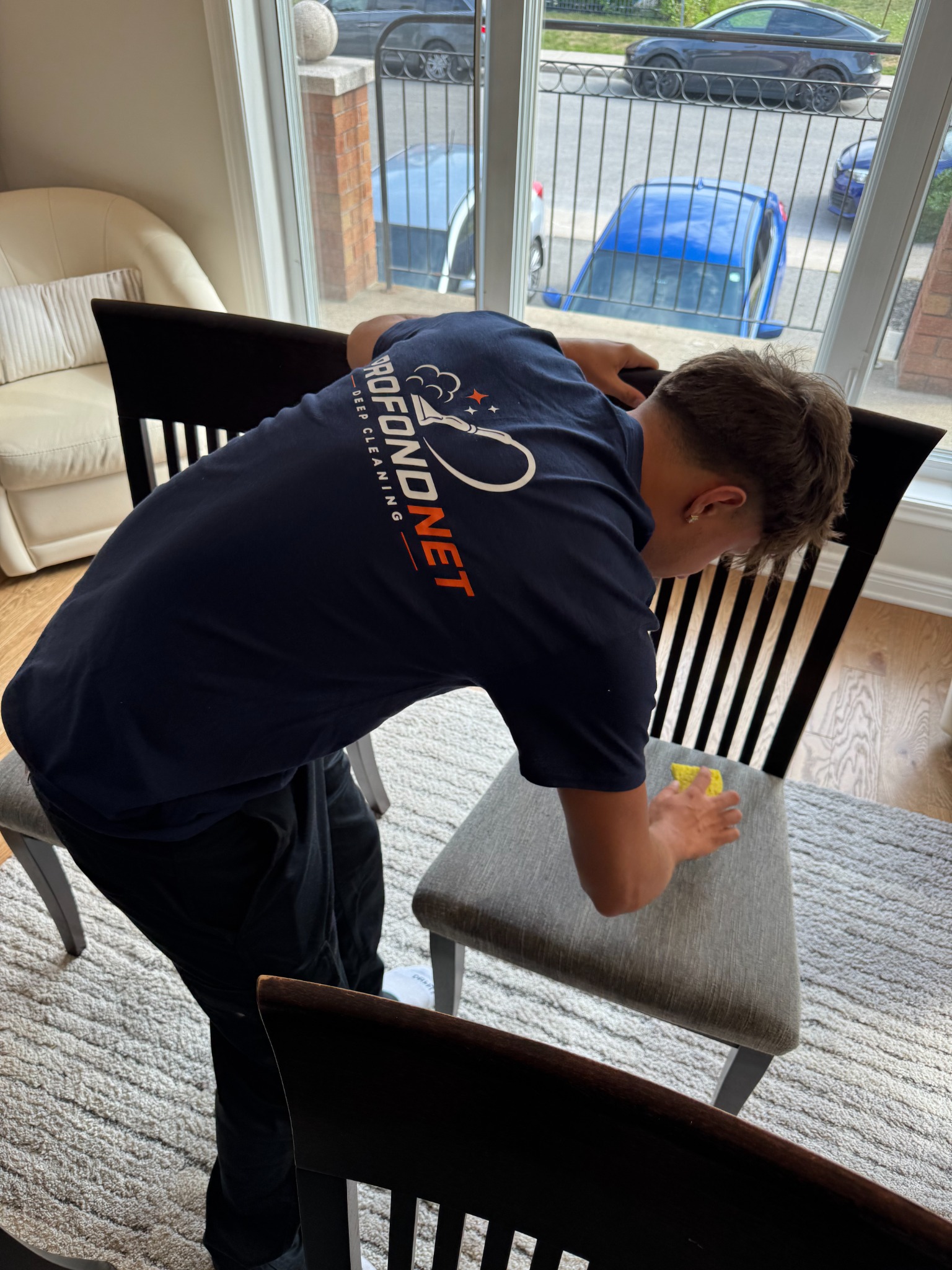 ProfondNet team member carefully cleaning an upholstered chair